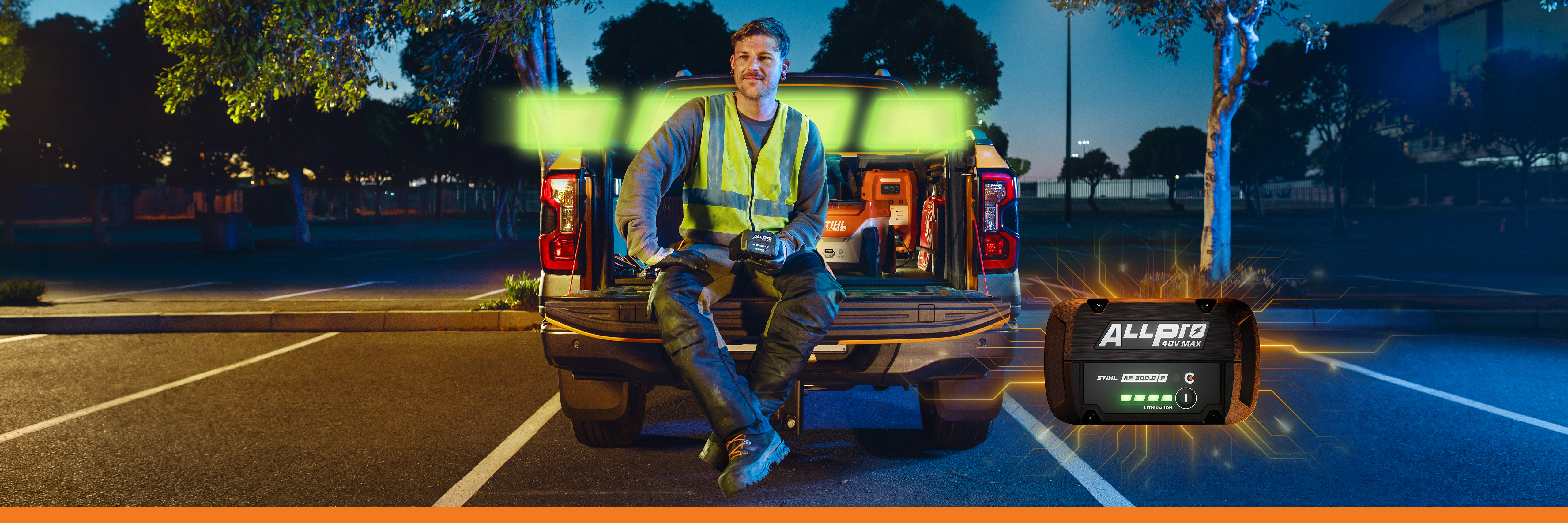 Back of a truck, while holding the STIHL AP 300 PC, with a graphic battery element and the STIHL ALLPRO battery system unit.  