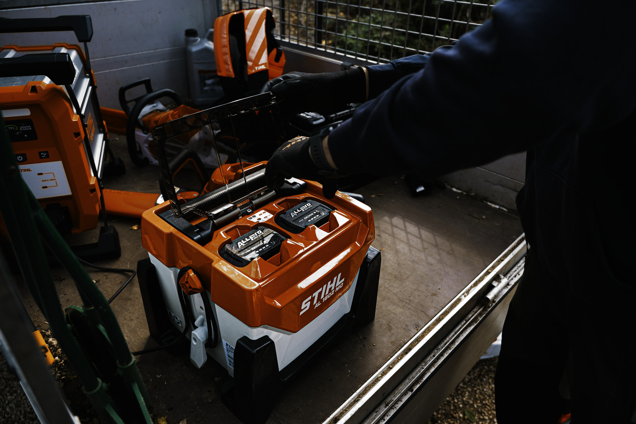 Un homme en train de brancher une batterie ALLPRO sur un chargeur rapide