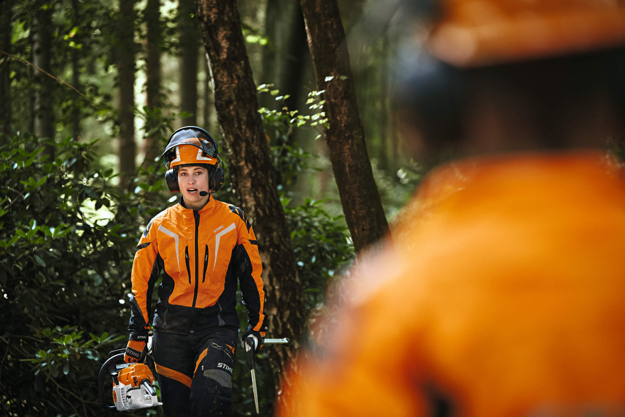 Deux ouvriers forestiers en vêtements de protection STIHL avec le système de conférence STIHL ADVANCE ProCOM 