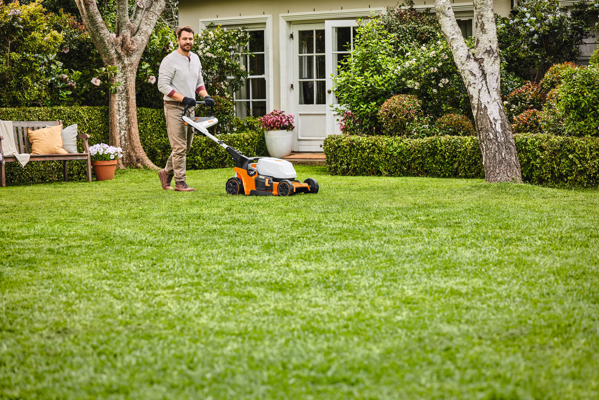An individual mowing there lawn with a STIHL battery lawn mower. 