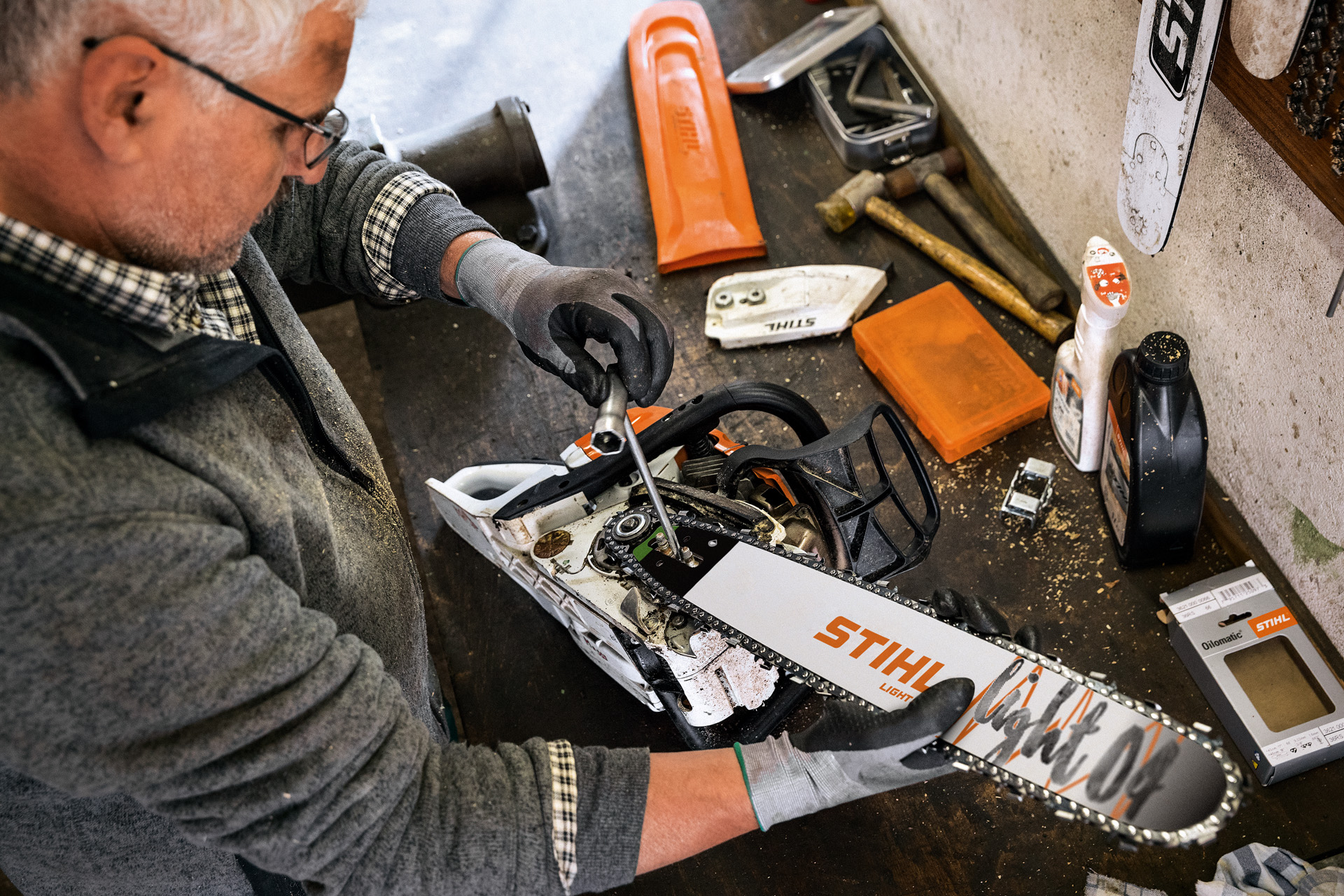 A STIHL dealer services a chainsaw that features a STIHL Light 04 guide bar and Oilomatic saw chain