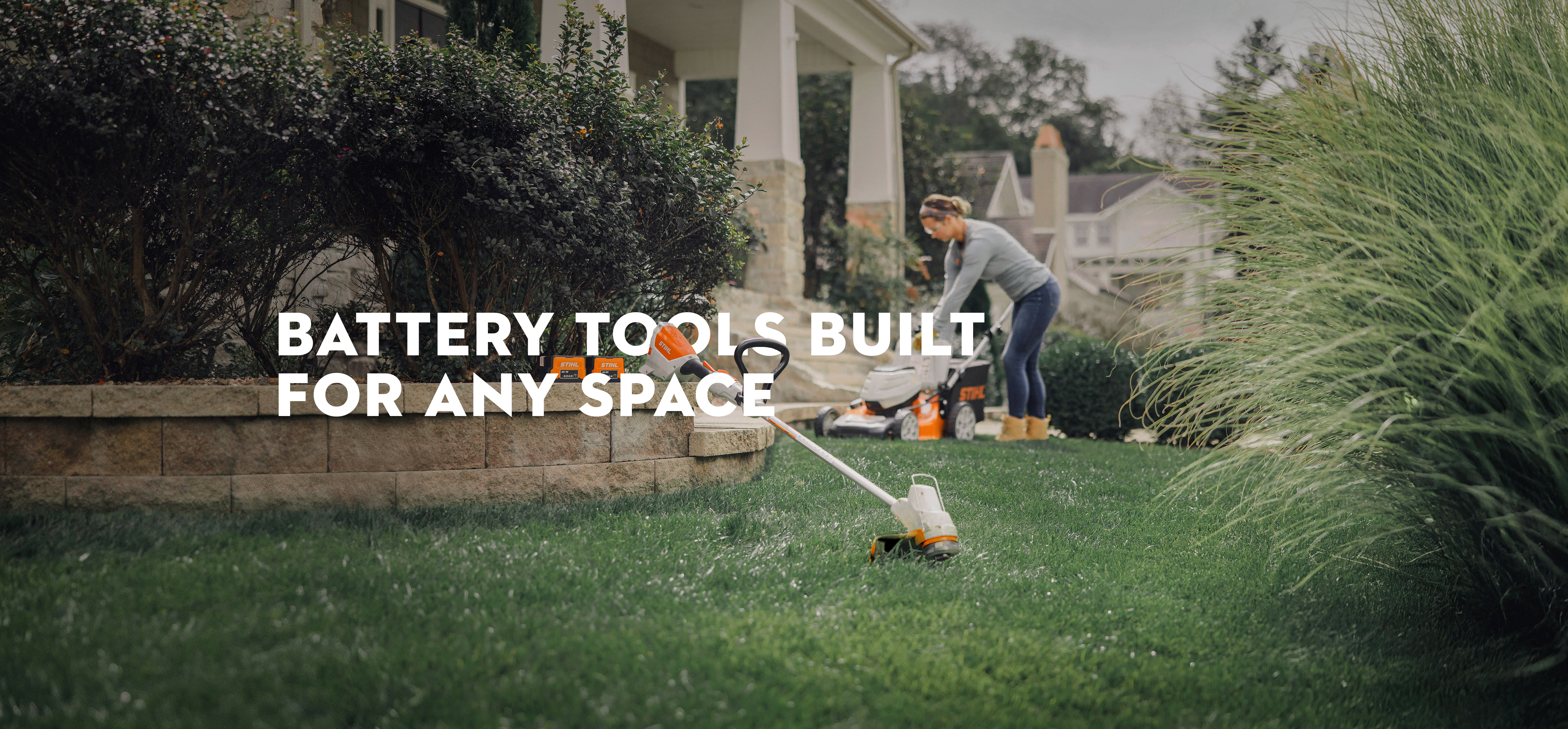 A woman using STIHL AK Battery System tools to do yard work. 