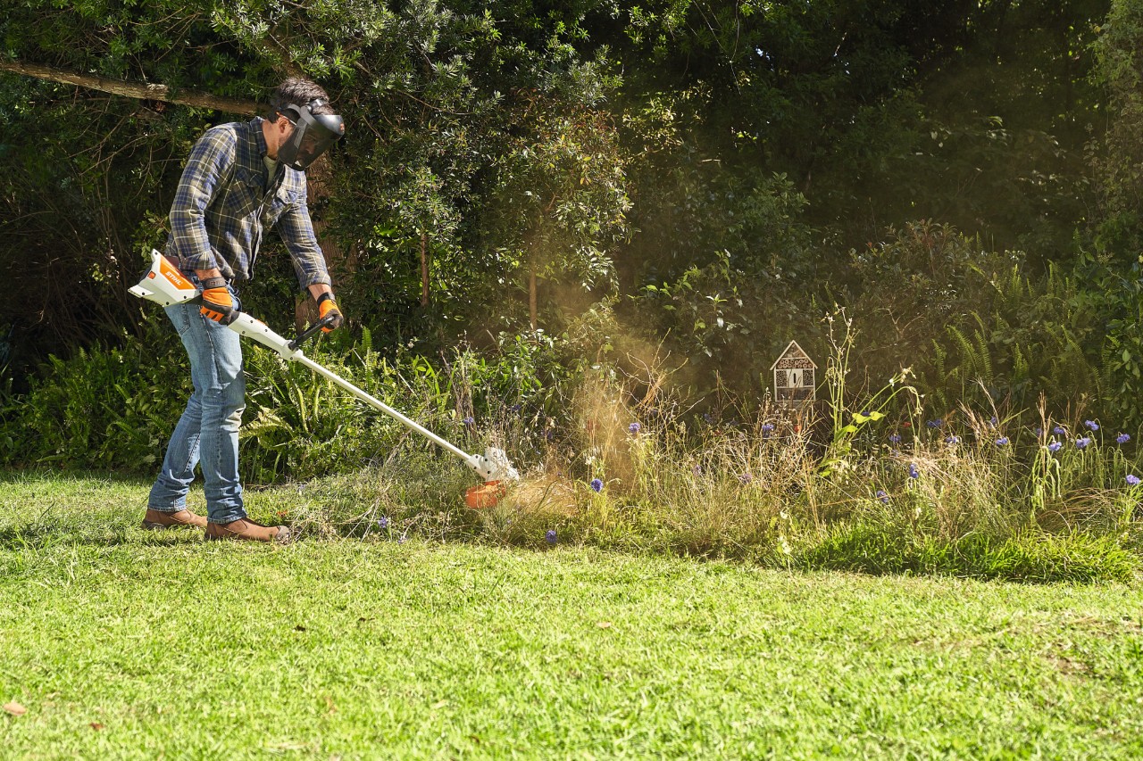 A man mowing a wildflower meadow with a STIHL FSA 57