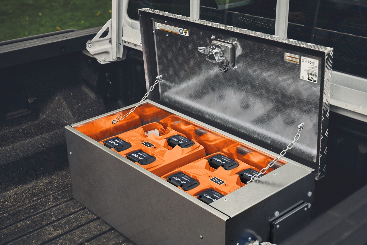 Station de recharge STIHL CB 1 avec batteries ALLPRO sur le plateau d'un pick-up